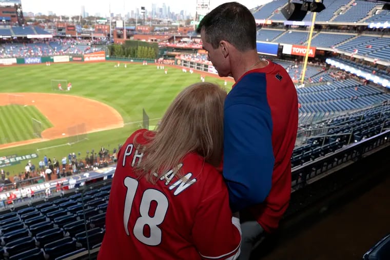 Corey Phelan’s parents Christie (left) and Chris Phelan embrace as they watch batting practice before Game 4 of the World Series.