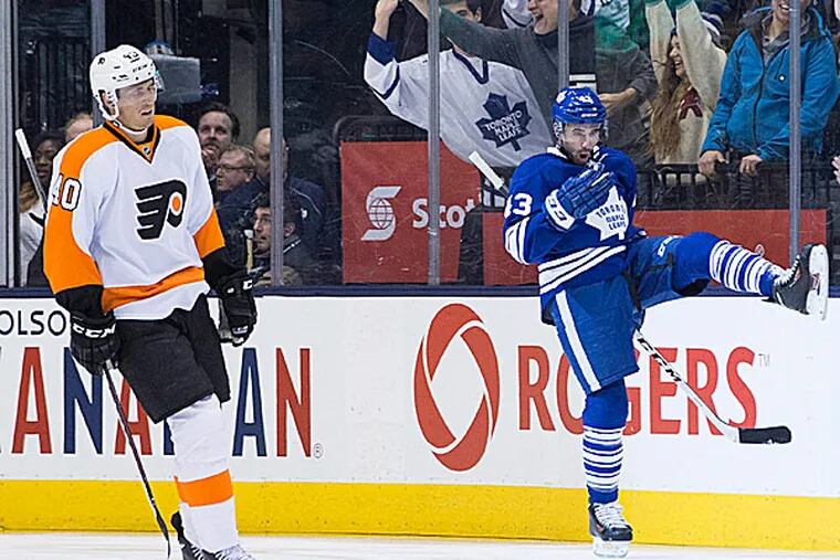 The Maple Leafs' Nazem Kadri celebrates scoring a goal as the Flyers' Vincent Lecavalier skates past during the first period. (Chris Young/The Canadian Press/AP)