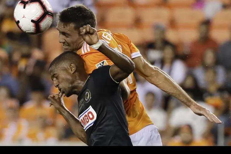 The Union's Fafa Picault and Houston Dynamo's Andrew Wenger, top,  battle for a shot during the first half of the U.S. Open Cup final.