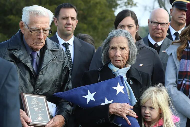 Listening to Taps being played at the conclusion of services for their brother, Army Sgt. Karl R. Loesche, are (left) Richard Loesche, of Florida, and Marion Atkinson, of Bensalem, Pa..  Her great-grandaughter, Marin VanGilder, 8, is at her side. The remains of Sgt. Loesche, who perished in a POW camp in 1942, had been interred as unidentified in a military cemetery in the Philippines until a DNA match with his last two surviving siblings was made three months ago.