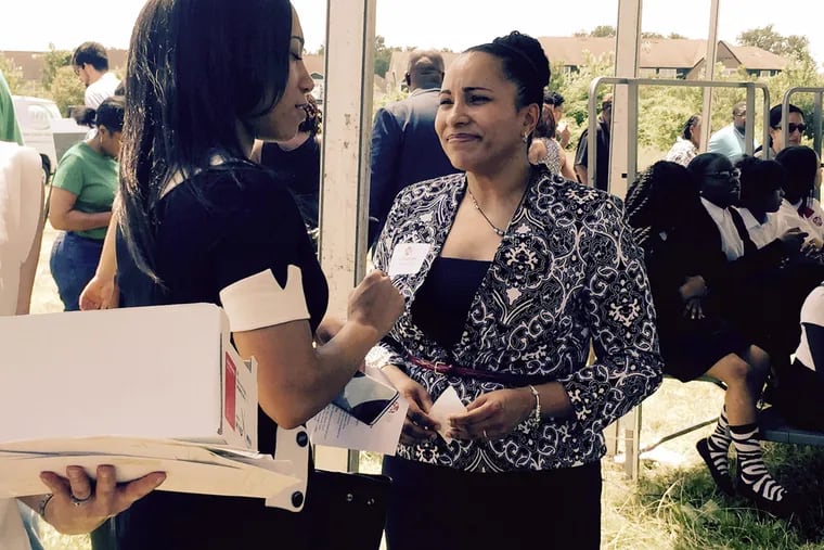 Akosua Watts, head of school, talks to an attendee at the groundbreaking ceremony for Chester Charter School for the Arts' new school building on Thursday, June 2, 2016.