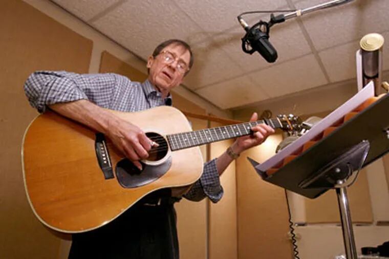 Emmet Robinson is helping baby boomers preserve their music keepsakes by restoring old records and tapes and transferring them to compact discs. He is shown playing his Martin acoutic guitar in the recording studio. (Charles Fox / Staff Photographer)