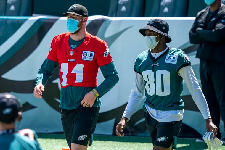 Philadelphia Eagles quarterback Carson Wentz, left, comes out to the field with wide receiver Quez Watkins, right, during an NFL football practice, Sunday, Aug. 30, 2020, in Philadelphia. (AP Photo/Chris Szagola, Pool)