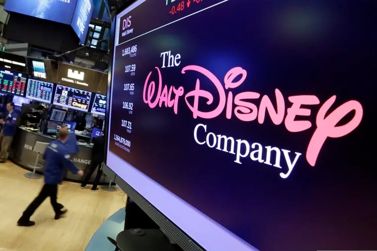 FILE - In this Aug. 8, 2017, file photo, The Walt Disney Co. logo appears on a screen above the floor of the New York Stock Exchange. On Thursday, April 11, Disney unveiled details of its long-awaited streaming service Disney Plus.