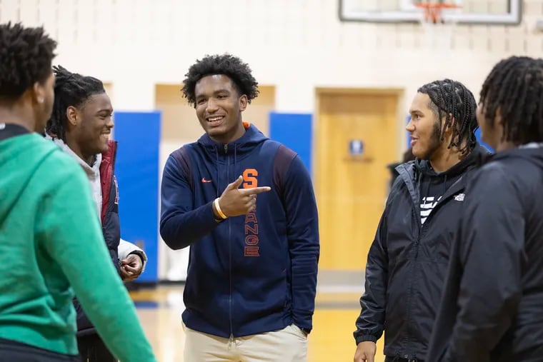 Winslow Township's Jaylan Hornsby (center) signed Wednesday to play football at Syracuse. He jokes with teammates and friends after the signing.