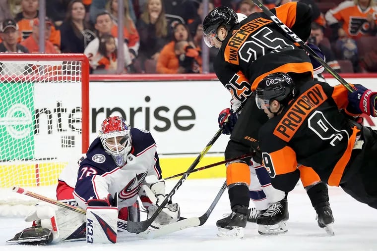 Blue Jackets goaltender Sergei Bobrovsky makes a save with his mask as the Flyers' James van Riemsdyk and Ivan Provorov try to get a rebound in their Dec. 22 meeting. The Flyers dropped a 4-3 decision despite outshooting the Jackets 37-19.