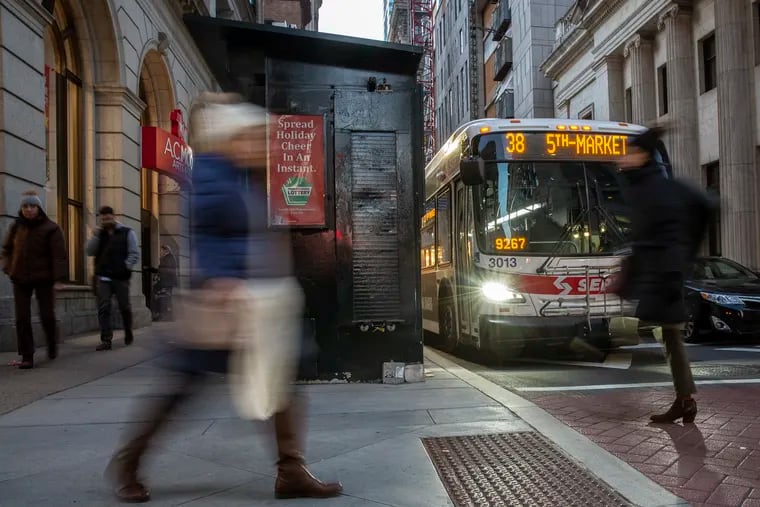 Pedestrians walk in front of a SEPTA bus at Chestnut and Broad during rush hour on Tuesday, Dec. 11, 2018. Gridlock from both heavy pedestrian traffic in the shopping district and congestion has made it difficult for Septa's most basic service. HEATHER KHALIFA / Staff Photographer