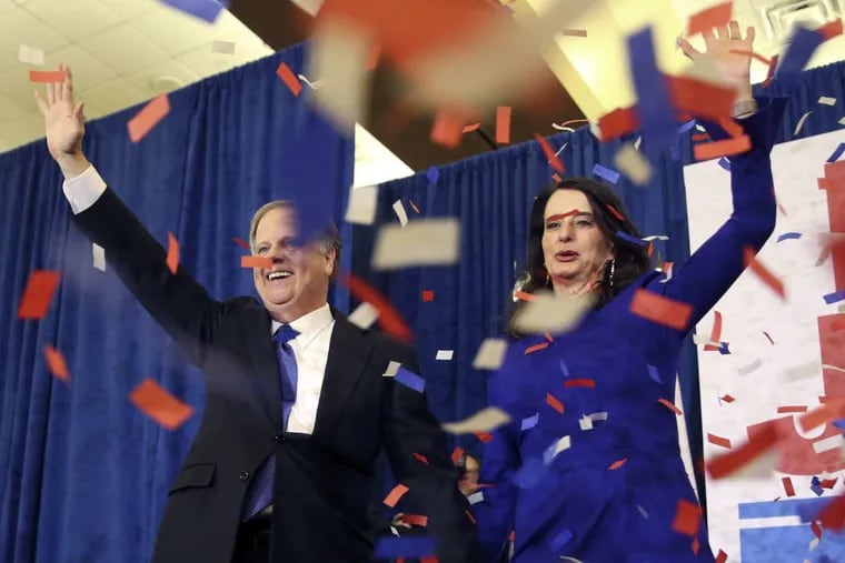 Democrat Doug Jones and his wife, Louise, celebrate his victory in Tuesday’s special Senate election in Alabama.