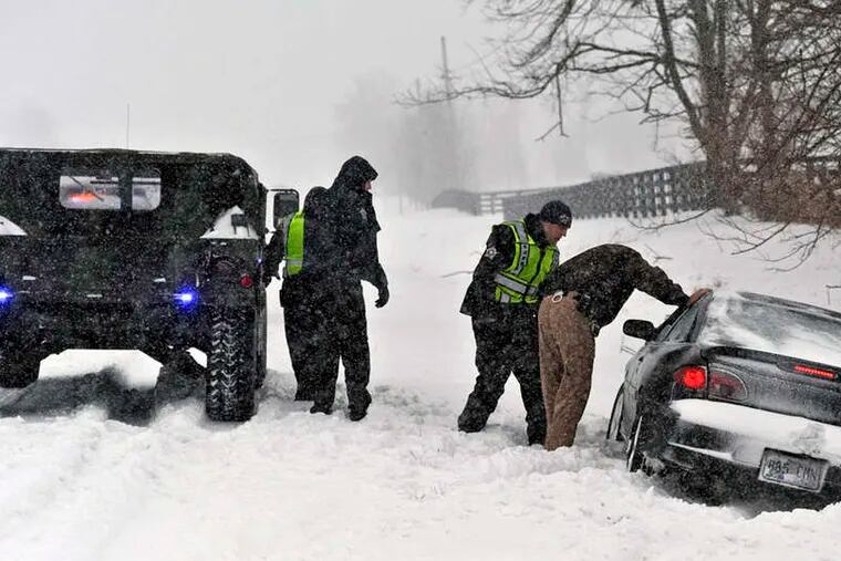 Boyle County sheriff's deputies traveling in a Hummer help a stranded motorist during a heavy snowstorm on U.S. 127 near Danville, Ky. The motorist had been headed to Danville Monday for medical treatment.