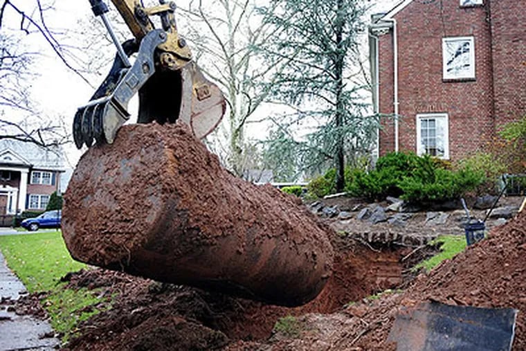 A 1,000-gallon oil tank is removed from underground Nicole Idler's front lawn in Teaneck, New Jersey. The Idler family switched from oil to gas and Lombardo Environmental removed their tank. (Amy Newman / The Record / MCT)