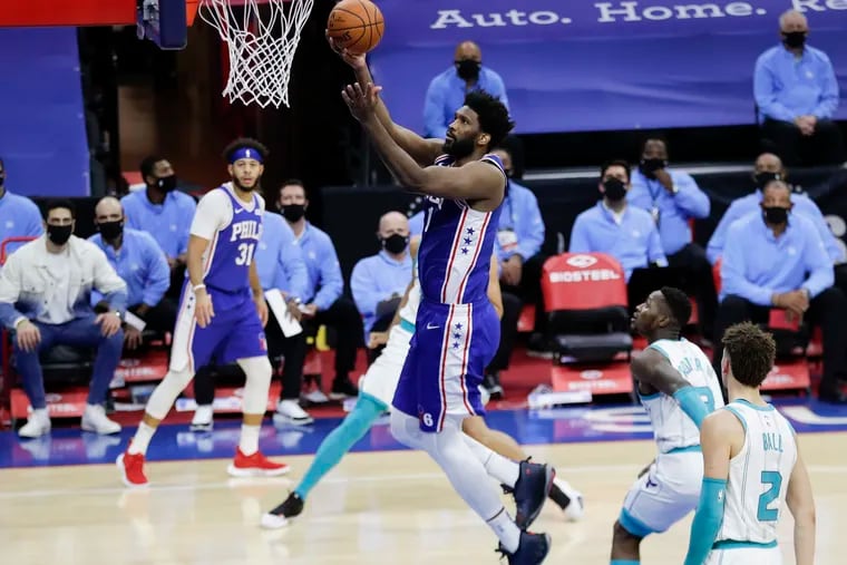 Sixers center Joel Embiid lays-up the basketball against Charlotte on Monday.