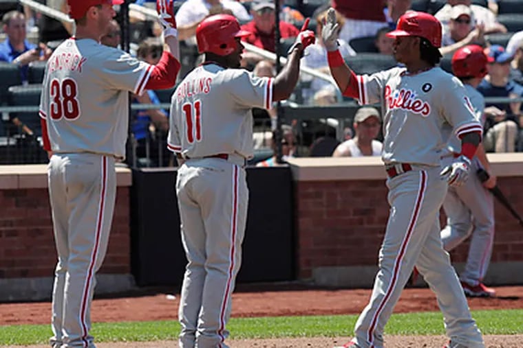 Kyle Kendrick and Jimmy Rollins greet Michael Martinez after his thee-run home run in the fifth inning. (Seth Wenig/AP)