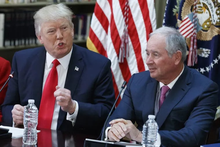 Blackstone Group CEO Stephen Schwarzman, (right) listens as President Trump speaks during a meeting with business leaders in the State Department Library on the White House complex.