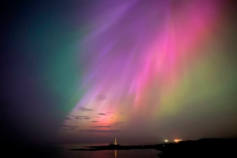 The aurora borealis, also known as the northern lights, glow on the horizon at St. Mary's Lighthouse in Whitley Bay on the North East coast, England.