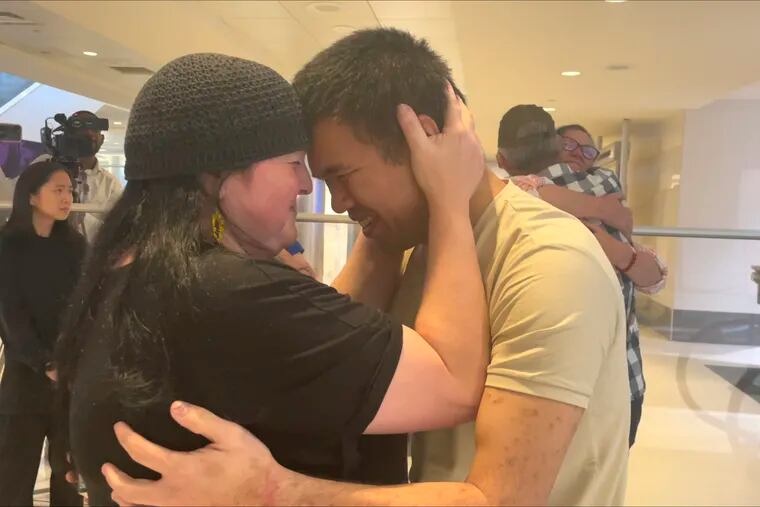 Andy Huynh, center, and Alex Drueke, far right, hug their loved ones after arriving at Birmingham-Shuttlesworth International Airport in Birmingham, Ala., on Saturday.