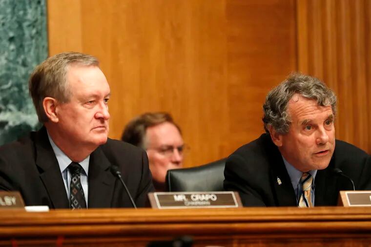 Senate Banking Committee Chairman Mike Crapo (R., Idaho) (left) and the committee's ranking Democrat, Sherrod Brown of Ohio, listen as Federal Reserve Chairwoman Janet Yellen testifies.