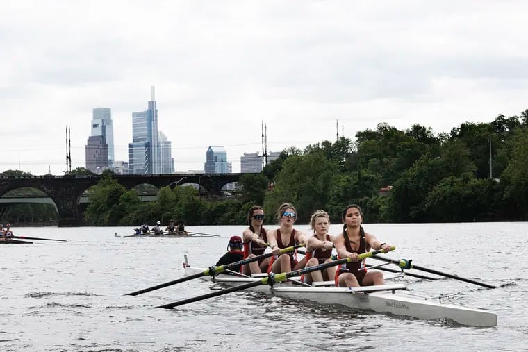 Members of the Sidwell Friends rowing team from Washington, D.C., take their boat to the starting line on May 19, 2023, during the Stotesbury Cup Regatta on the Schuylkill.