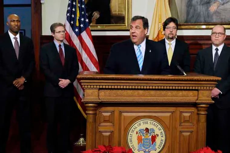 New Jersey Gov. Chris Christie, center, is flanked by Marc Larkins, left, Matt Boxer, second left, Chris Porrino, right, and Charlie McKenna as he announces staff changes in his administration in Trenton, N.J., Thursday, Dec. 19, 2013. New Jersey Comptroller Matt Boxer will be stepping down and entering the private sector; Marc Larkins will leave School Development Authority to become Comptroller; Chief Counsel Charlie McKenna will become CEO for the School Development Authority and Chris Porrino will leave the Division of Law to replace McKenna as Governor’s new Chief Counsel. (AP Photo/Mel Evans)