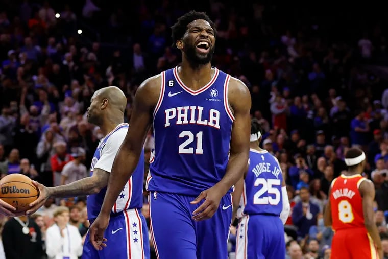 Sixers center Joel Embiid laughs after Atlanta Hawks forward John Collins missed a free throw late in the game on Monday.