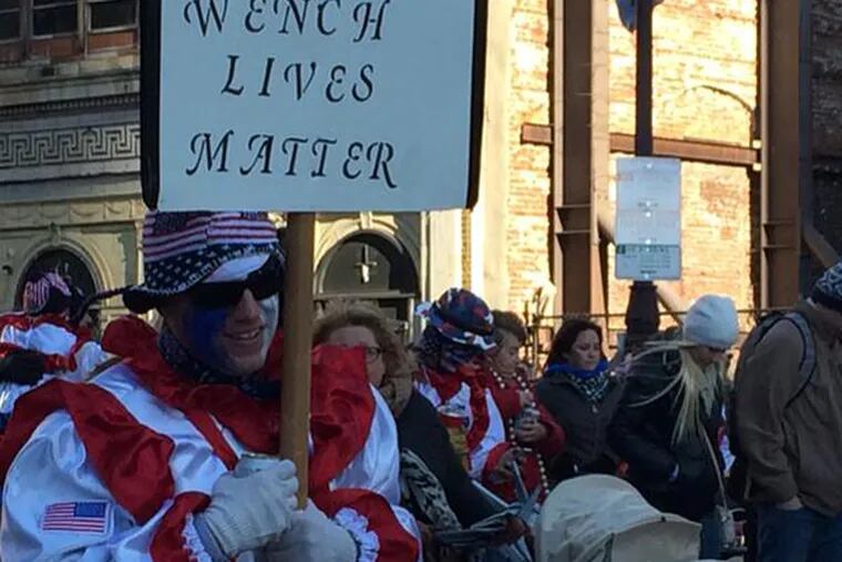 An unidentified member of a Comic Wenches group carried a sign that drew some ire on social media, Thursday, Jan. 1, 2015. (DAVID GAMBACORTA/STAFF)