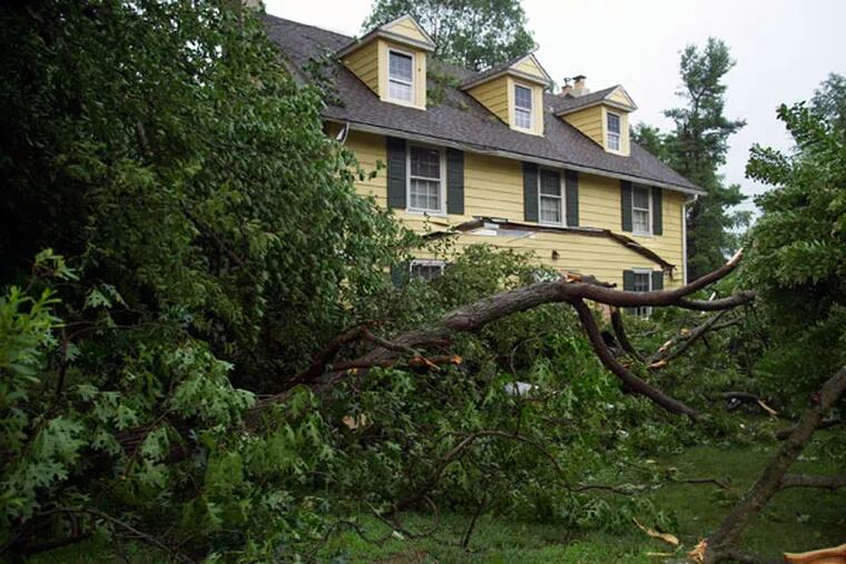 Part of a tree fell onto the front porch of a house on Westtown-Thornton Road in Thornton, collapsing the roof after a severe thunderstorm rolled through the area June 23, 2015. (CLEM MURRAY/Staff Photographer)