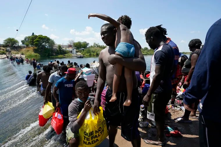 Haitian migrants use a dam to cross into the United States from Mexico on Saturday in Del Rio, Texas. The Biden administration plans the widescale expulsion of Haitian migrants by putting them on flights to Haiti starting Sunday, an official said Friday.