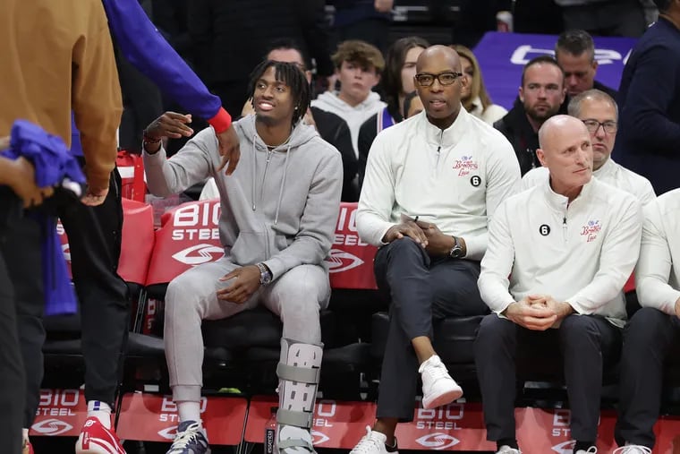 Tyrese Maxey wearing a walking boot as he sat on the bench before the Sixers' game against the Timberwolves at the Wells Fargo Center on Saturday.