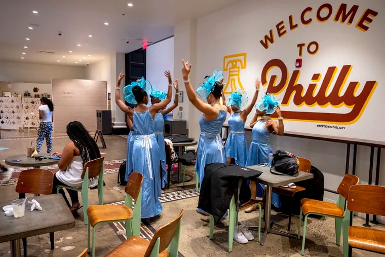 Members of the Dance4Life troupe from Claymont, Del., warm up inside the Bourse food court before their scheduled Wawa Welcome America performance in the Gospel on Independence Mall Sunday evening was canceled due to severe storms in the forecast.