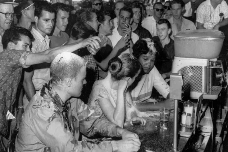 In an iconic photo from the civil rights era, white people pour sugar, ketchup and mustard on the heads of sit-in demonstrators at a Woolworth’s lunch counter in Jackson, Miss., on May 28, 1963.