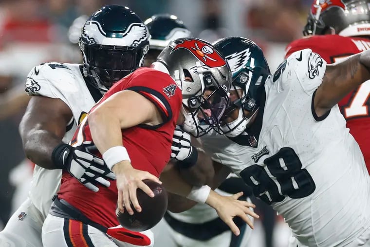 Eagles defensive tackles Fletcher Cox (left) and Jalen Carter go after Tampa Bay Buccaneers quarterback Baker Mayfield in the last seconds of the second quarter.