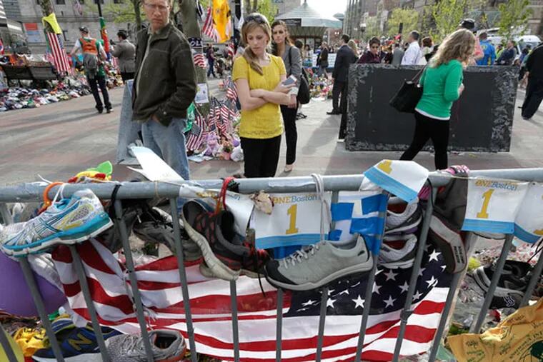 People pause to look at a makeshift memorial near the Boston Marathon finish line in Boston's Copley Square Tuesday, May 7, 2013 in remembrance of the Boston Marathon bombings. (AP Photo/Steven Senne)