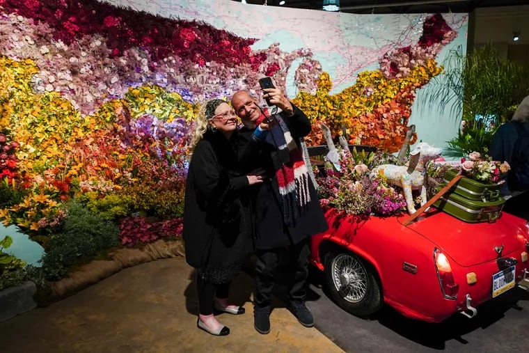 Dr. Ahmed Draz and his wife Joanie Draz take a selfie in front of the “America in Bloom" display by Jennifer Designs, at the annual Pennsylvania Horticultural Society (PHS) Philadelphia Flower Show, at the Pennsylvania Convention Center.