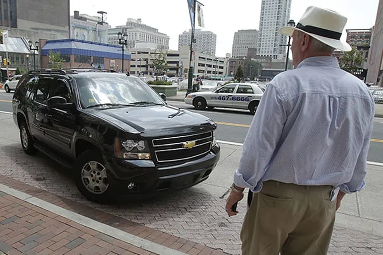 Reporter Paul Nussbaum watches an Uber Black car pull in front of him on Market Street.( AKIRA SUWA  /  Staff Photographer )