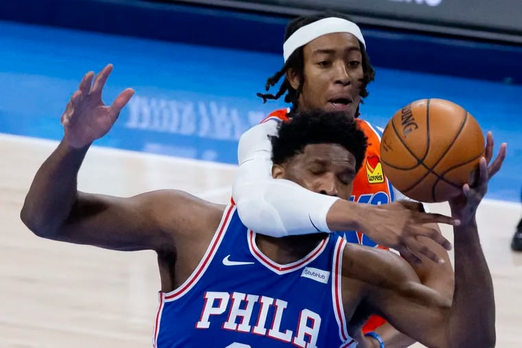 Oklahoma City Thunder center Moses Brown (9) fights for the ball with Philadelphia 76ers center Joel Embiid (21) during the first half of an NBA basketball game, Saturday, April 10, 2021, in Oklahoma City. (AP Photo/Garett Fisbeck)