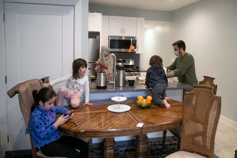 Mohibullah Hasrat, right, is photographed with his wife and children, from left, Taeeba, 7, Beheshta, 3, and Mohammad Rizwan, 2, inside their home in West Philadelphia. Finding affordable houses for Afghan evacuees has been challenging.