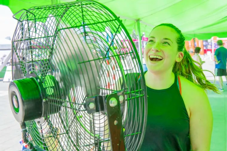 Standing in front of one of the many fans in the workout tents, Julie Cohen cools off after her Fit Camp workout, part of the Wawa Welcome America festivitites, at the foot of the Philadelphia Art Museum steps Sunday.