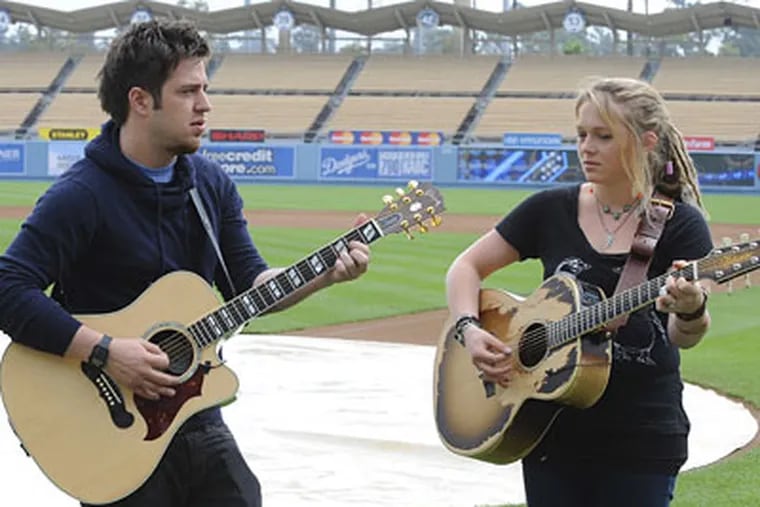 "American Idol" finalists Lee DeWyze (left) and Crystal Bowersox look like competitors during a duet at Dodger Stadium.
