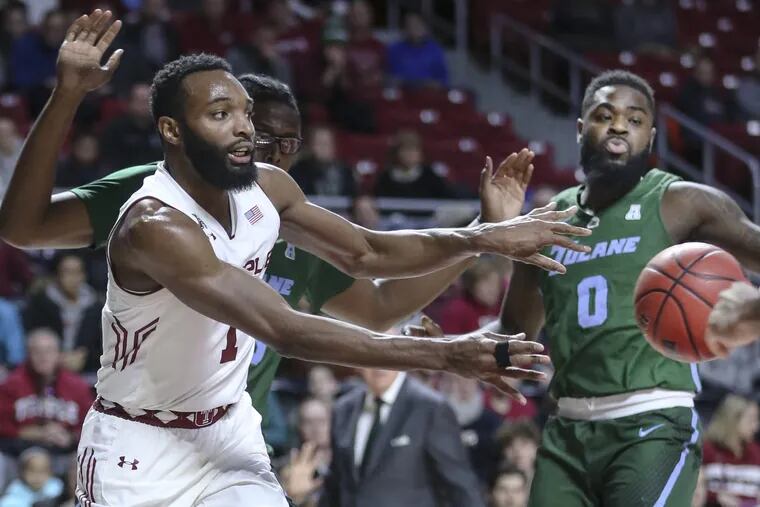 Temple's Josh Brown passes in front of Tulane's Jordan Cornish during the first half at the Liacouras Center.