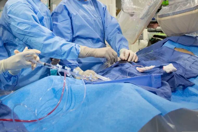 In this Feb. 16, 2017 file photo, surgeons perform a non-emergency angioplasty at Mount Sinai Hospital in New York. Through a blood vessel in the groin, a tube is guided to a blockage in the heart. A tiny balloon is then inflated to flatten the clog, and a mesh tube called a stent is inserted to prop the artery open.