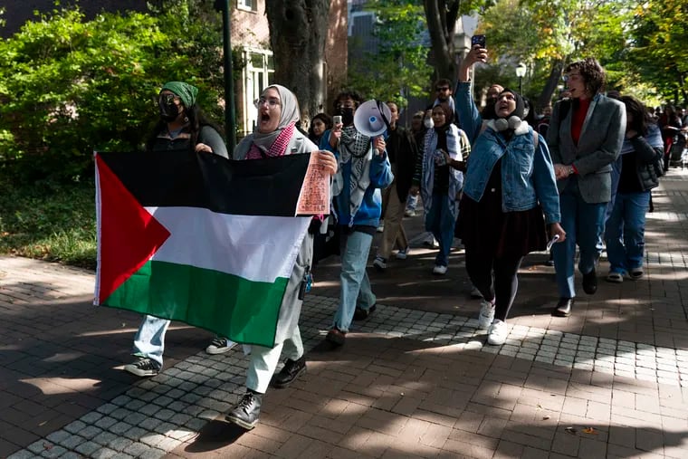Penn students and supporters march down Locust Walk in support of Palestine and in criticism over president Liz Magill’s comments on Monday, Oct. 16, 2023.