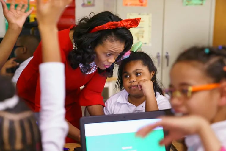 Principal Fatihah Abdul-Rahman (left) works with student Turori Morris (center) during one of her daily classroom observations at Forest Hill Elementary School in Camden, N.J.