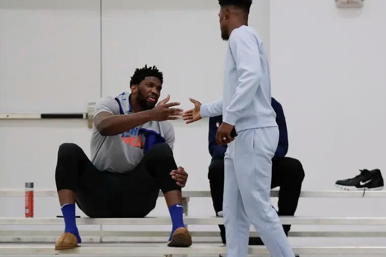 Sixers center Joel Embiid greets teammate guard Jimmy Butler before the start of practice at Basketball City in New York on Friday.