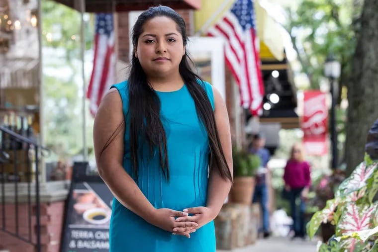Anel Medina, 26, a registered nurse at Chester County Hospital stands on main street of her hometown, Kennett Square, where she has lived since she was 5.