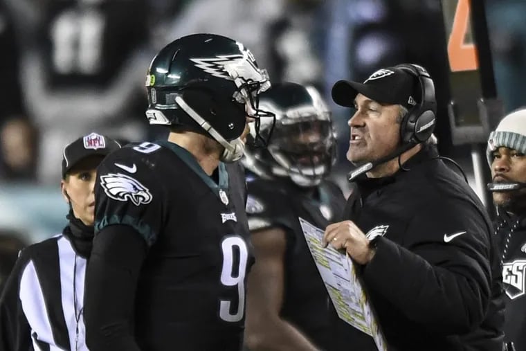 Eagles coach Doug Pederson gives quarterback Nick Foles instructions along the sidelines during the game against the Oakland Raiders at Lincoln Financial Field in a Monday Night Football game Christmas night 2017. Eagles won 19-10. CLEM MURRAY / Staff Photographer