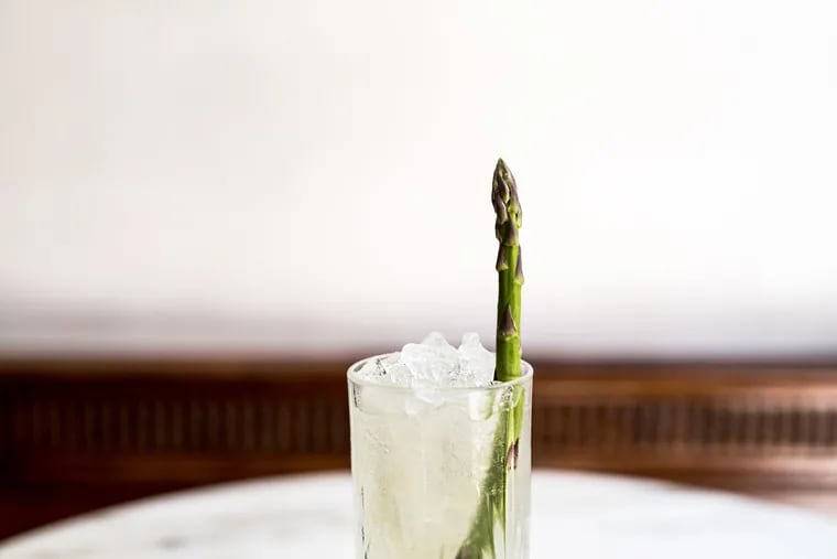 At Friday Saturday Sunday, bartender Paul MacDonald garnishes one of his newest creations, the Alsatian Swizzle, with a bright green asparagus stalk, designed to capture the attention of diners in the room.