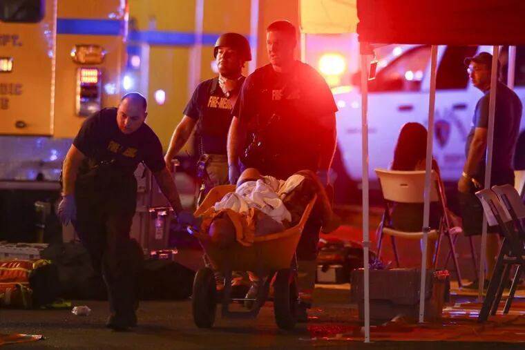 A wounded person is taken away in a wheelbarrow as Las Vegas police respond during an active shooter situation on the Strip in Las Vegas.