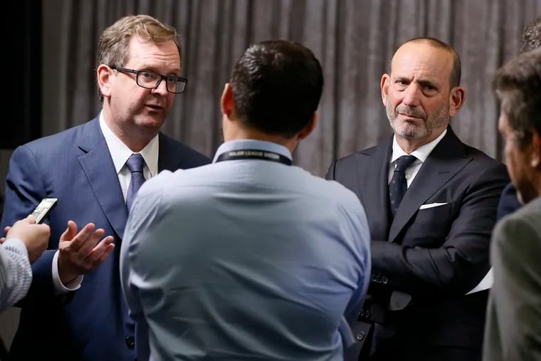 Major League Soccer President and Deputy Commissioner Mark Abbott (left) and Commissioner Don Garber (right) talk with the media in Los Angeles after a MLS Board of Governors meeting on April 18, 2019.