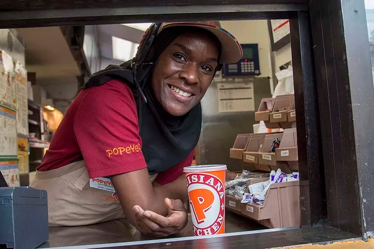 Jones working the window at the Popeyes at Broad and Catharine, where she has worked since 2009 and makes $8.50 an hour.