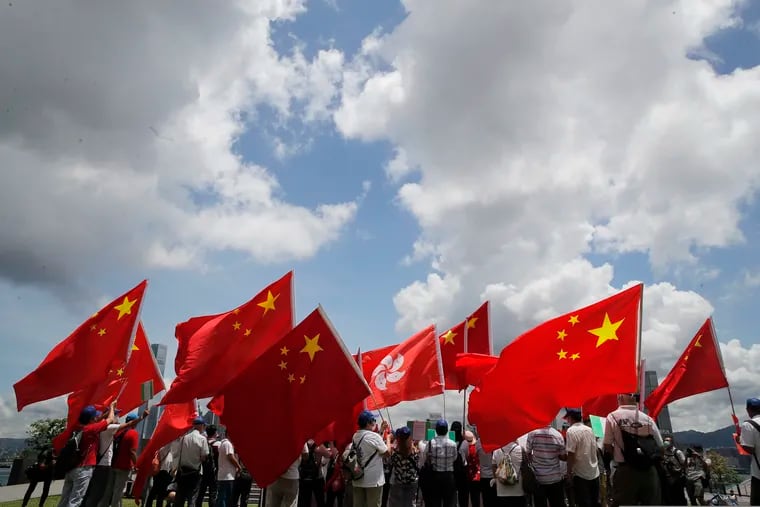 Pro-China supporters hold Chinese and Hong Kong national flags during a rally to celebrate the approval of a national security law for Hong Kong, in Hong Kong.