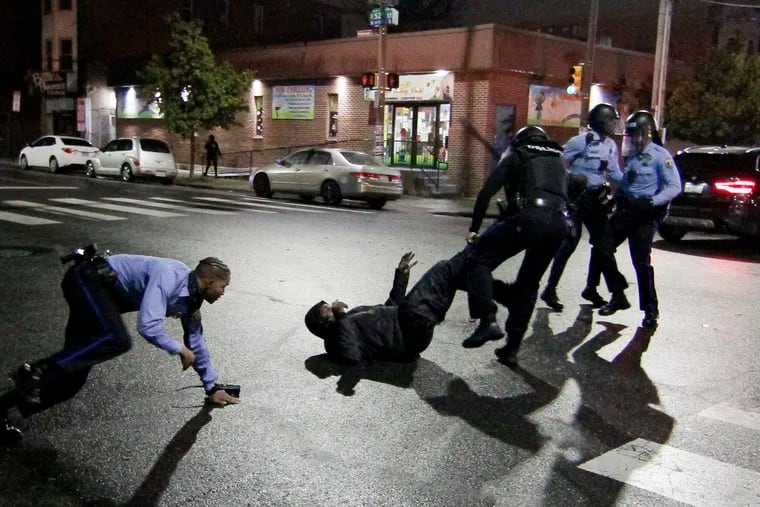 Police tackle a man they were chasing at 52nd and Locust Streets early Tuesday during protests after officers shot and killed Walter Wallace Jr. in West Philadelphia.